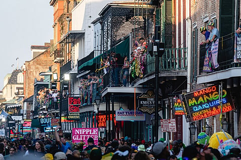 (FILE PHOTO) Mardi Gras participants on balconies overlook celebrants walking down Bourbon Street on 21 February, 2023 in New Orleans, Louisiana.