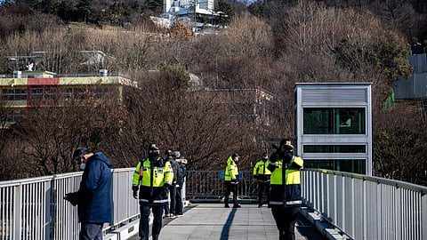 Police officers stand guard outside of impeached South Korea president Yoon Suk Yeol's residence (back) in Seoul on January 2, 2025.