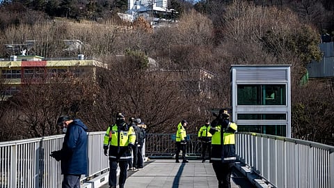 Police officers stand guard outside of impeached South Korea president Yoon Suk Yeol's residence (back) in Seoul on January 2, 2025.