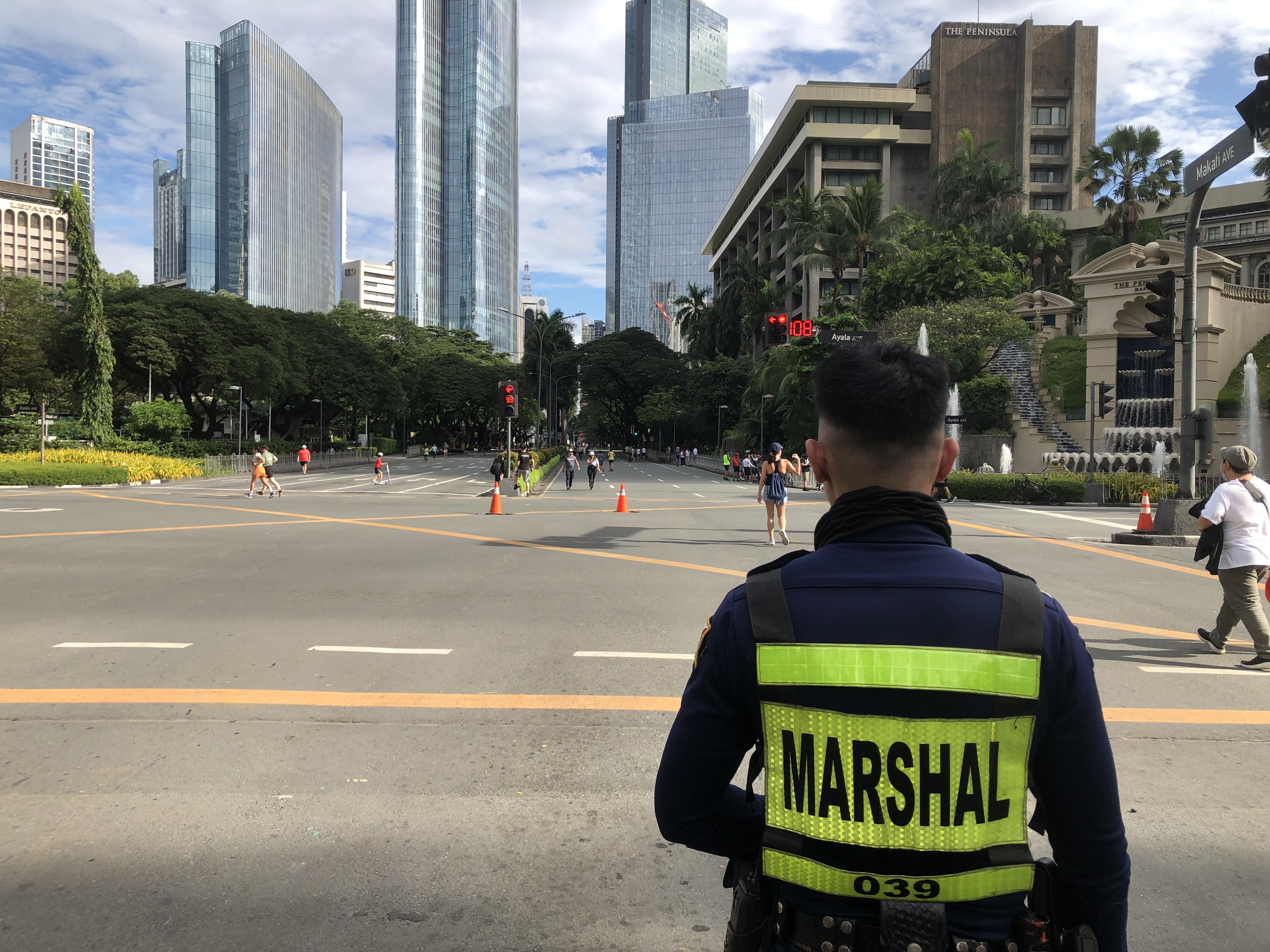 At Ayala and Makati Avenue, a marshal watches as cyclists, skaters and joggers bring the car-free streets to life.