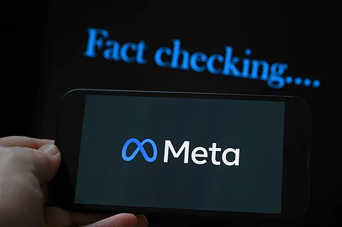 (FILES) This photo illustration created on 8 January 2025, in Brussels, shows the media giant Meta's logo displayed on a smartphone and screen displaying the words "fact checking". Brazil on 10 January 2025, gave social media giant Meta 72 hours to explain its fact-checking policy for the country, and how it plans to protect "fundamental rights" on its platforms. Attorney General Jorge Messias told journalists his office could take "legal and judicial" measures against Meta if it does not respond in time to an extrajudicial notice filed Friday.