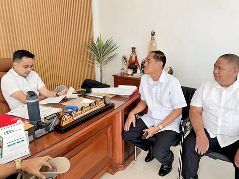 Mayor Richie Jason David (left) and Land Transportation Office chief Ronald O. Navarette (LTO chief, Bataan) agreed Monday to conduct an LTO caravan to assist residents in this industrial town. At right is Bong Biliwang, an LTO staff member.
