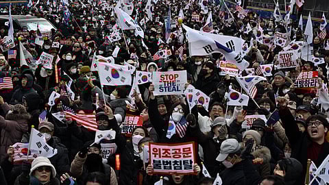 Pro-Yoon supporters wave flags as they gather on a road outside the Seoul Western District Court in Seoul on 18 January 2025, as the court weighs whether to extend the detention of impeached South Korea President Yoon Suk Yeol after investigators arrested him over a failed martial law bid. Yoon, who has claimed his arrest and investigation is illegal, threw the nation into chaos on 3 December when he attempted to suspend civilian rule, citing the need to combat threats from "anti-state elements".