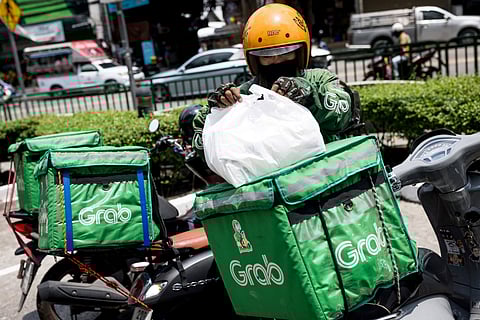 A food delivery driver loads an order onto his motorcycle.