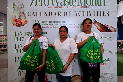 Three employees of manpower company Omniworx show off the grocery packs they received at the 14th Recyclables Collection Event on 13 January.