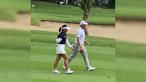 Justin delos Santos (right) and Rianne Malixi chat while walking the first fairway of the Masters on Sunday.