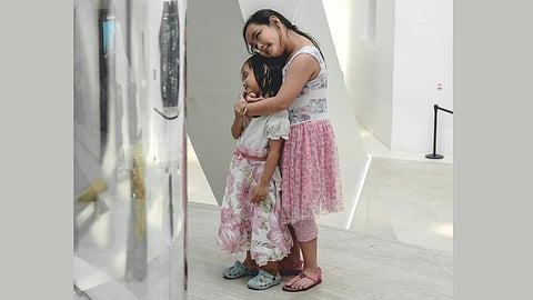 An affectionate embrace: A young older sister shares a loving hug with her little sister, reminding us of the simple joys of connection.