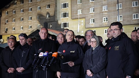 Turkish Interior Minister Ali Yerlikaya (C) speaks to the media outside a hotel where a fire broke out in the Kartalkaya Ski Resort in Bolu, northwestern Turkey, on 21 January 2025. A huge fire killed at least 76 people Tuesday as it ripped through a hotel at a popular ski resort in northern Turkey that was packed with people enjoying the winter holidays, including families.