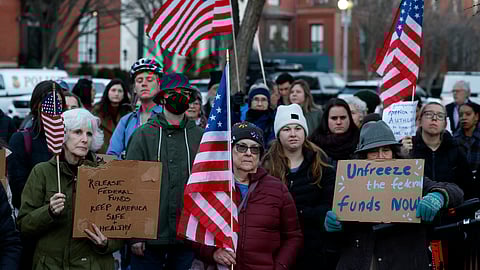 Activists protest against President Donald Trump's plan to stop most federal grants and loans during a rally near the White House on 28 January 2025 in Washington, DC. The Trump Administration announced it would freeze federal grant funding, a move that could halt payments for state and local programs like SNAP food aid, housing assistance, education, healthcare, and climate initiatives.