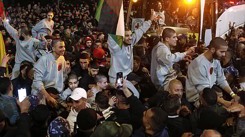 A crowd welcomes Palestinians formerly jailed by Israel as they arrive in a Red Cross convoy to Ramallah in the occupied West Bank on 30 January 2025. Buses carrying freed Palestinian prisoners arrived to cheers in the occupied West Bank on 30 January 2025, after chaos during the release by Gaza militants of three Israeli hostages and five Thais led to a brief delay in the process.