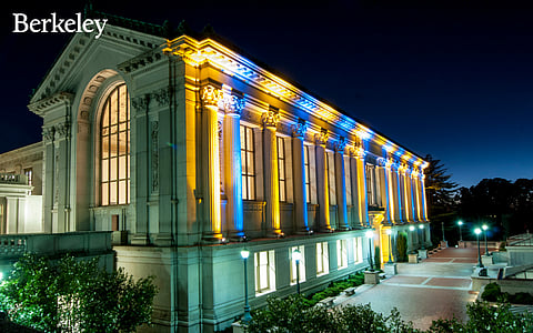 Doe Library lit up in blue and gold