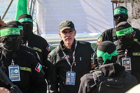 Palestinian militant group Hamas fighters escorts American-Israeli hostage Keith Siegel before handing him over to a Red Cross team in Gaza City on February 1, 2025, as part of the fourth hostage-prisoner exchange.