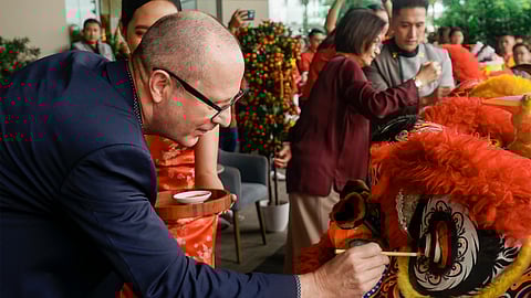 Nils Rothbarth, General Manager of Lanson Place Mall of Asia, paints a red dot on the eye of a Chinese Lion.