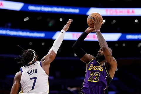 LeBron James of the Los Angeles Lakers takes a jump shot over Buddy Hield of the Golden State Warriors in the second half of an NBA game on 6 February (US time) in Los Angeles.
