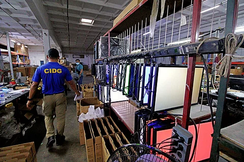 CIDG Police Capt Jan Michael Jardin shows off the monitors that were being made into counterfeit TVs at an electronics store at the Corregidor Highway, Ilanin West District of the Subic Bay Freeport.
