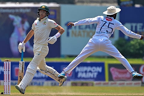 Australia's Marnus Labuschagne (L) runs between the wickets as Sri Lanka's Dhananjaya de Silva jumps to field the ball during the fourth day of the second Test cricket match between Sri Lanka and Australia at the Galle International Cricket Stadium in Galle on 9 February 2025.