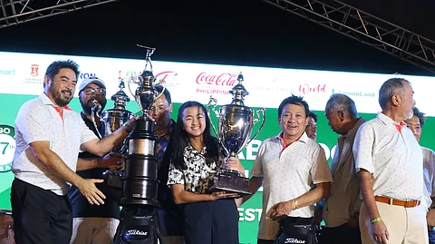 Raymond Abelido, represented by daughter Robyn, and Temie Lambino accept their trophies for securing the overall net title in the 37th Mango Tee Invitational late Saturday at the Alabang Country Club.