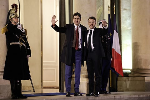 French President Emmanuel Macron (R) gestures as he welcomes Canada's Prime Minister Justin Trudeau (L) to the Elysee Palace ahead of a working dinner, on the eve of the Artificial Intelligence (AI) Action Summit, in Paris, on February 9, 2025.