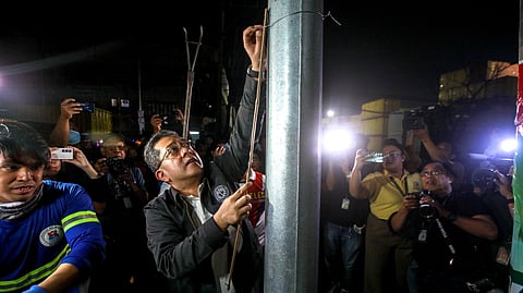 COMMISSION on Elections Chairman George Garcia removes a campaign poster that had been inappropriately placed on a lamp post on Tuesday.