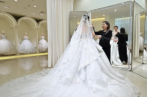 WOMAN fits her wedding dress at a bridal shop in Luliang, northern China’s Shanxi province on 11 February 2025. Luliang is one of many places in China where local authorities are now offering a slew of inducements to coax couples into tying the knot.