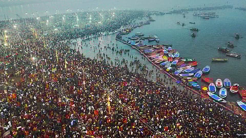Hindu pilgrims taking a holy dip in the sacred waters of Sangam, the confluence of the Ganges, Yamuna and mythical Saraswati rivers, during the Maha Kumbh Mela festival in Prayagraj, Uttar Pradesh, India, on 13 January.
