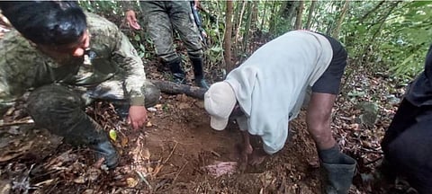 Members of the Philippine Army check the unearthed arms cache by insurgents in Gabaldon, Nueva Ecija.