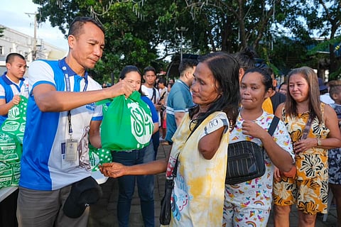 An SM Foundation volunteer hands a bag of groceries to a PWD during its Operation Tulong Express relief goods distribution to victims of typhoon ‘Kristine’ in Cavite City in October.