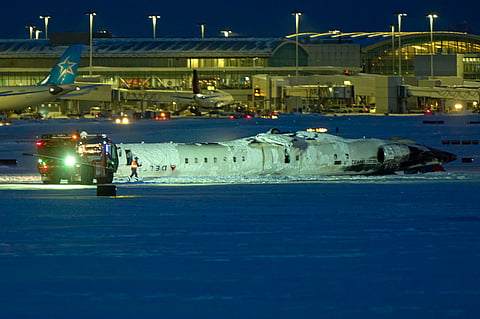 A Delta airlines plane sits on its roof after crashing upon landing at Toronto Pearson Airport in Toronto, Ontario, on February 17, 2025. A Delta Air Lines jet with 80 people onboard crash landed Monday at the Toronto airport, officials said, flipping upside down and leaving at least 15 people injured but causing no fatalities.