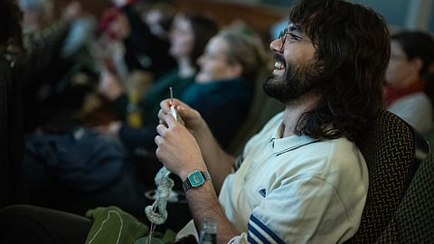 A man knits during the projection of the movie 'The Devil Wears Prada' at the Votive Cinema in Vienna, Austria, on 16 February 2025. Equipped with yarn and needles, dozens of dexterous moviegoers flock to a Viennese cinema every month to combine their favourite hobbies: knits and flicks.