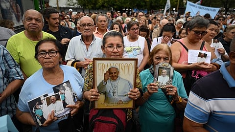 Faithful Catholics hold portraits of Pope Francis as they attend a mass for his healing in Constitution Square, the place where, when he was archbishop of Buenos Aires he gave annual masses to denounce exclusion and human trafficking in Buenos Aires, on 24 February 2025.