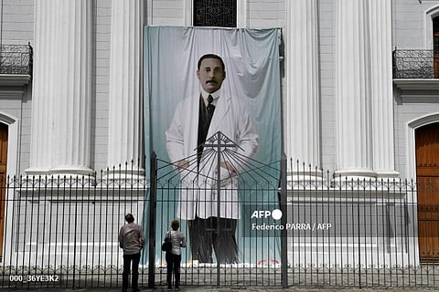 LOOK: People look at an image of Venezuelan doctor Jose Gregorio Hernandez outside La Candelaria church, which holds his remains, in Caracas, on June 21, 2020. Pope Francis, hospitalized in 'critical' condition, authorized the canonization of the "doctor of the poor" José Gregorio Hernández, who will become Venezuela's first saint, the Venezuelan Catholic Church said on 25 February 2025.
Hernandez, a Venezuelan physician who died more than 100 years ago, is revered as a "doctor of the poor" for his selfless service during the Spanish flu pandemic.