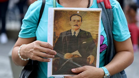 A woman holds a portrait of Venezuelan doctor Jose Gregorio Hernandez at La Candelaria Church in Caracas on 25 February 2025. Pope Francis, hospitalized in 'critical' condition, authorized the canonization of the "doctor of the poor" Jose Gregorio Hernandez, who will become Venezuela's first saint, the Venezuelan Catholic Church said on 25 February 2025.