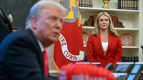 White House Press Secretary Karoline Leavitt (R) looks on as US President Donald Trump speaks to the press next to hats reading "Trump was right about everything", after signing an Executive Order at the Oval Office of the White House in Washington, DC on 25 February 2025.