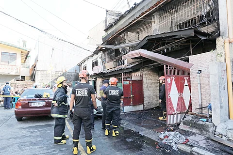 Personnel from the Bureau of Fire Protection investigate the rental house in Barangay San Isidro, Galas, Quezon City which was razed by a fire last Thursday. At least eight individuals were confirmed dead in the blaze.