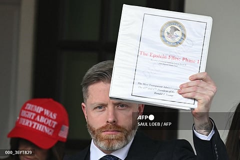 Political commentator Rogan O'Handley, aka DC Draino, and other unidentified people carrying binders bearing the seal of the US Justice Department reading "The Epstein Files: Phase 1" walk out of the West Wing of the White House in Washington, DC, on February 27, 2025. The Trump administration has said it would release documents on late tycoon and convicted sex trafficker Jeffrey Epstein who was found dead in his prison cell in 2019.