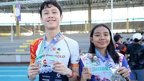 Emmanuel Go (left) and Mielle Cabiguen showcase their trophies and medals after clinching top honors in the premier division of the RLC Residences IRONKIDS on Saturday in Puerto Princesa City.