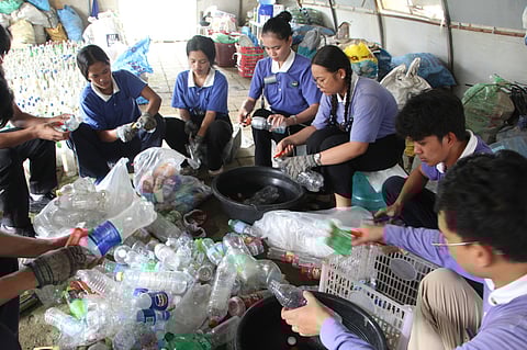 Tzu Chi Ormoc scholars and youth clean discarded plastic bottles for recycling at the Great Love Village on 23 February.