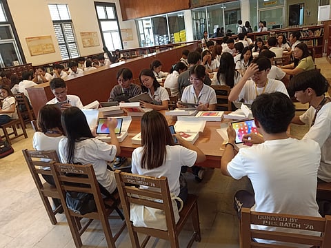 Students of Pampanga High School try the AI-enabled tablets pre-loaded with DTP e-modules donated by Globe.