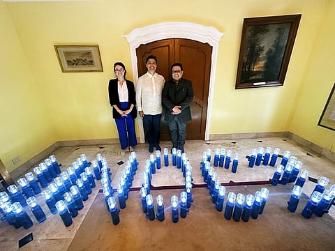 Liter of Light founder Illac Diaz (center) with Embassy of France staff show arranged hand-built solar-powered lanterns at the residence of French Ambassador Marie Fontanel.