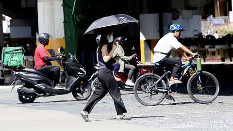 A female pedestrian uses her umbrella to protect herself from intense heat along EDSA in Quezon City last November 2024. PAGASA said that the northeast monsoon is expected to surge until midweek of March.