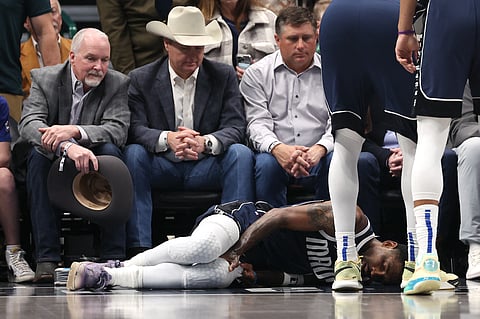 DALLAS, TEXAS - Kyrie Irving #11 of the Dallas Mavericks lies on the court after suffering an injury in the first half against the Sacramento Kings at American Airlines Center on 3 March 2025 in Dallas, Texas.