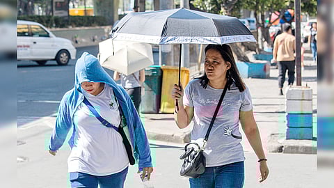PEDESTRIANS use umbrella for shade as they walk under the midday sun in Manila on Tuesday. PAGASA warns that the heat index in Metro Manila and other areas could reach a ‘danger’ level of 42 to 51 degrees Celsius as the peak of the dry season is expected from late March to April.