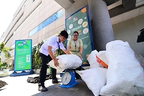 A student weighs recyclables with his teacher at SM Cares' Trash to Cash, proving that every small effort adds up to a greener future.