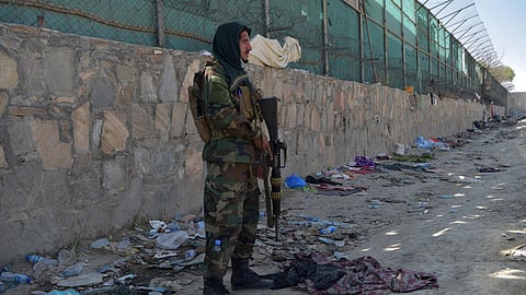 A Taliban fighter is pictured at the site of the Kabul airport bombing, which killed scores of people including 13 US troops