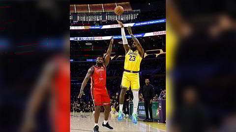 Lebron James shoots a three-pointer over Zion Williamson to notch 50,002 points during their 136-115 win over the New Orleans Pelicans in the NBA regular season.
