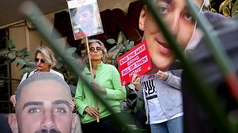 Israelis raise cutout portraits of hostages during a protest in Tel Aviv calling for the implementation of the second phase of the Gaza ceasefire