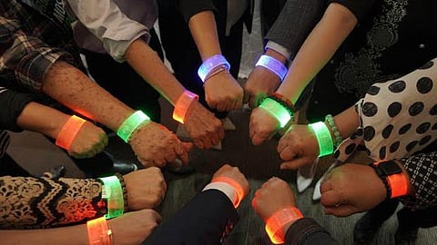 Patients, doctors, advocates and the private sector wear LED bands as part of the Light Up for Rare campaign.