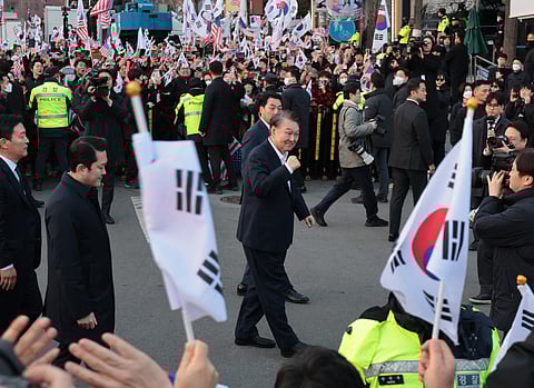Impeached South Korean President Yoon Suk Yeol reacts to his supporters as he arrives at the presidential residence in Seoul on March 8, 2025. Impeached South Korean President Yoon Suk Yeol was released from detention on March 8, after a court voided his arrest on procedural grounds -- but he remains under investigation over his declaration of martial law.