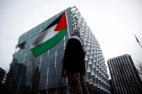 A protester waves a Palestinian flag in front of the US Embassy during a Pro-Palestinian march in central London, on February 15, 2025, organized by the Palestine Solidarity Campaign. Demonstrators gathered in London on February 15 to march from Whitehall to the US Embassy in what is expected to be one of the largest shows of solidarity for Palestinians.