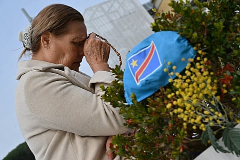 A woman prays at the statue of John Paul II outside the Gemelli University Hospital where Pope Francis is hospitalized with pneumonia, in Rome on 8 March 2025.
Pope Francis spent a quiet night in hospital, the Vatican said as the 88-year-old head of the Catholic Church battles pneumonia.